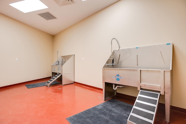 misc room featuring pet washing area and baseboards