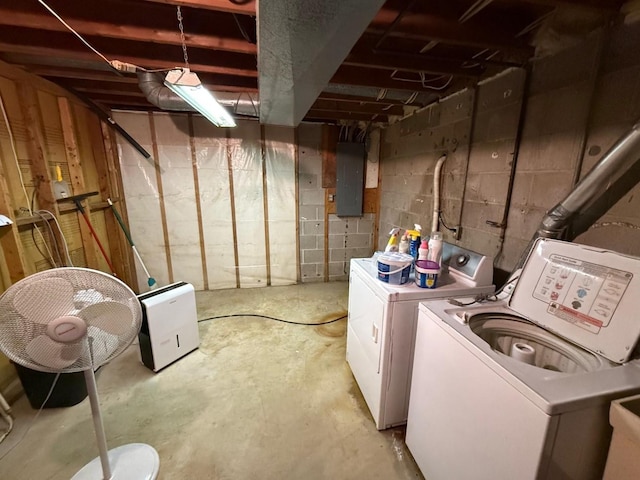 unfinished below grade area featuring electric panel and washing machine and dryer