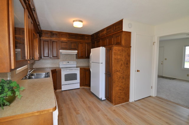 811 Pleasant Ave S, Park Rapids, MN 56470 - kitchen featuring a sink, white appliances, light wood-type flooring, under cabinet range hood, and light countertops
