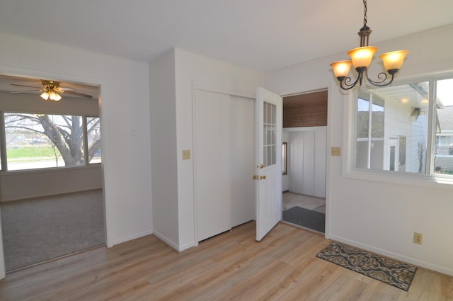 811 Pleasant Ave S, Park Rapids, MN 56470 - unfurnished dining area with plenty of natural light, light wood-style flooring, baseboards, and ceiling fan with notable chandelier