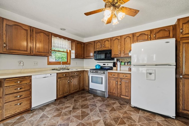 12201 Olive St NW, Coon Rapids, MN 55448 - kitchen with white appliances, a sink, brown cabinets, ceiling fan, and light countertops