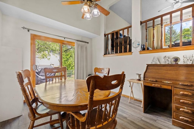 12201 Olive St NW, Coon Rapids, MN 55448 - dining area featuring a ceiling fan, wood finished floors, baseboards, and high vaulted ceiling