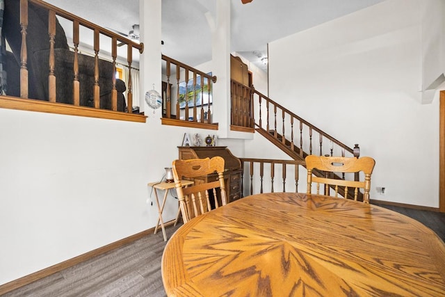 12201 Olive St NW, Coon Rapids, MN 55448 - dining space featuring wood finished floors, baseboards, stairway, a ceiling fan, and a towering ceiling