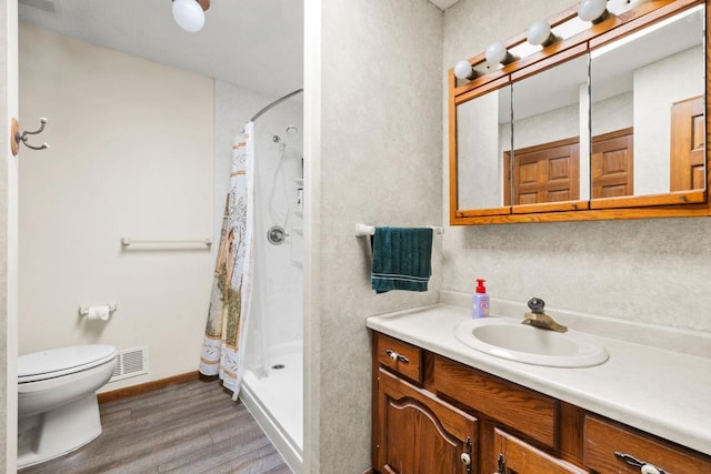 12201 Olive St NW, Coon Rapids, MN 55448 - bathroom with wood finished floors, a stall shower, toilet, and vanity