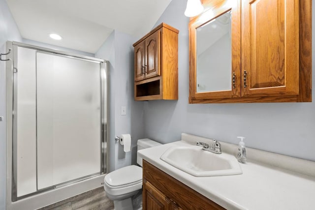 12201 Olive St NW, Coon Rapids, MN 55448 - bathroom with a stall shower, toilet, vanity, wood finished floors, and recessed lighting