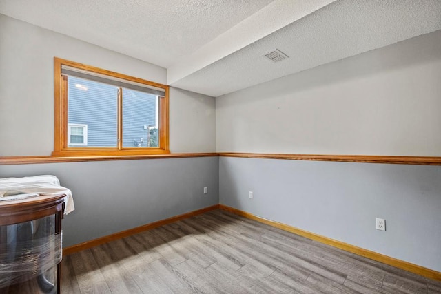 12201 Olive St NW, Coon Rapids, MN 55448 - empty room with wood finished floors, baseboards, and a textured ceiling
