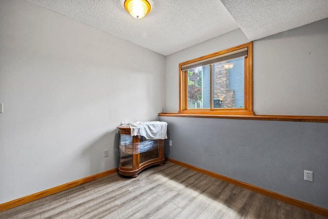 12201 Olive St NW, Coon Rapids, MN 55448 - empty room featuring a textured ceiling, wood finished floors, and baseboards