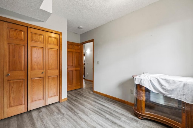 12201 Olive St NW, Coon Rapids, MN 55448 - bedroom featuring wood finished floors, baseboards, a textured ceiling, and a closet
