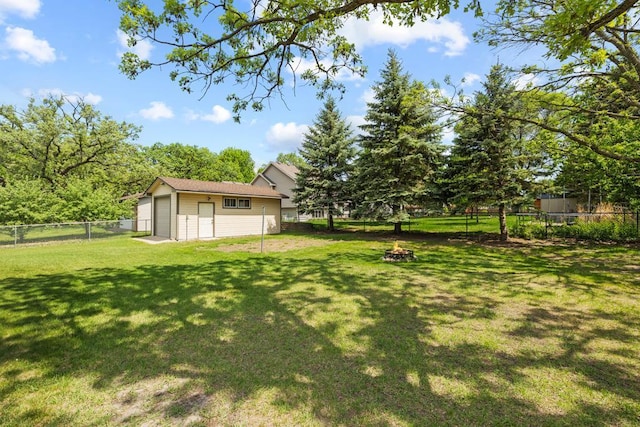 12201 Olive St NW, Coon Rapids, MN 55448 - view of yard featuring an outbuilding, an outdoor fire pit, and a detached garage