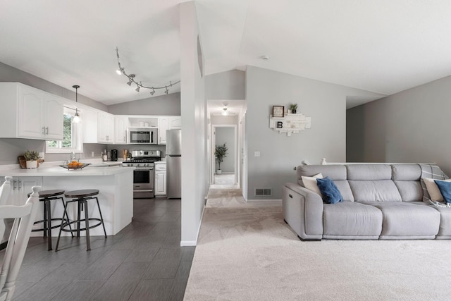 5046 Mitchell Rd, Big Lake, MN 55309 - living room featuring vaulted ceiling, dark carpet, and baseboards