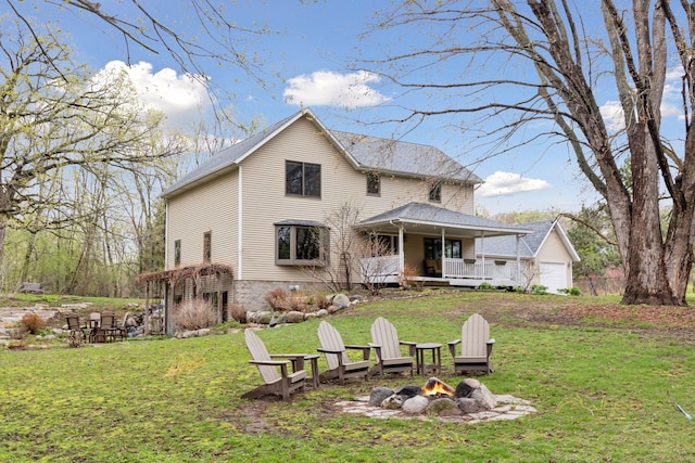 back of property featuring a yard and an outdoor fire pit