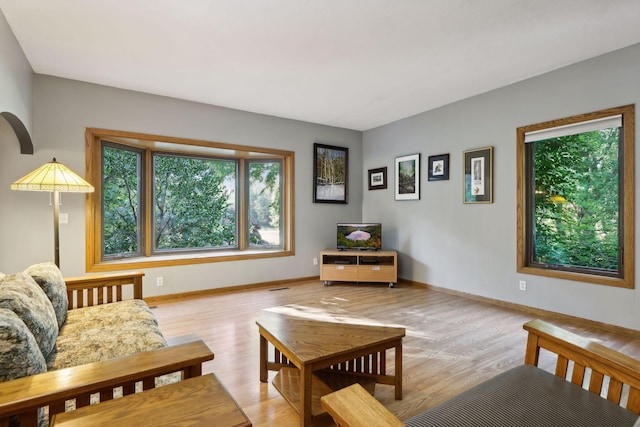 living area featuring light wood finished floors, visible vents, and baseboards