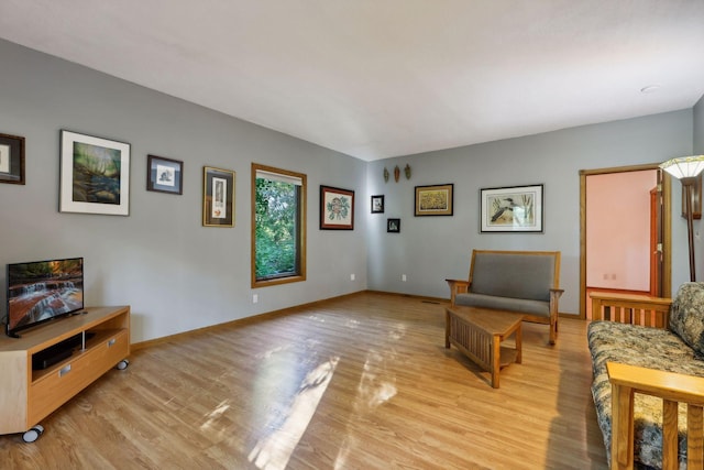 living area featuring light wood finished floors and baseboards