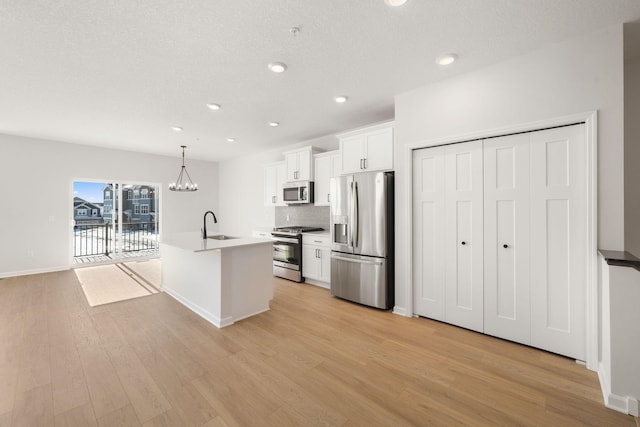 6738 Wildflower Way, Minnetrista, MN 55331 - kitchen featuring appliances with stainless steel finishes, light wood-style floors, a kitchen island with sink, white cabinetry, and recessed lighting