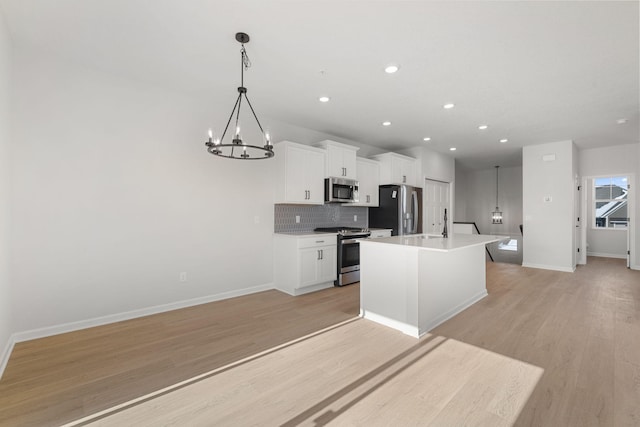 6738 Wildflower Way, Minnetrista, MN 55331 - kitchen featuring appliances with stainless steel finishes, an island with sink, a chandelier, baseboards, and recessed lighting