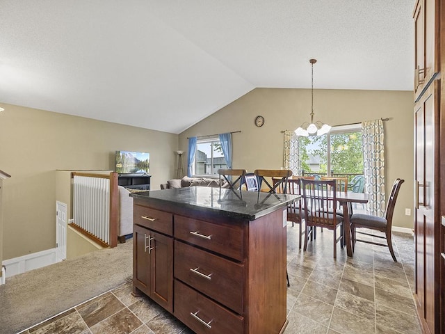 9185 Golden Pond Ln N, Monticello, MN 55362 - kitchen featuring light stone finish floors, dark countertops, lofted ceiling, a chandelier, and decorative light fixtures