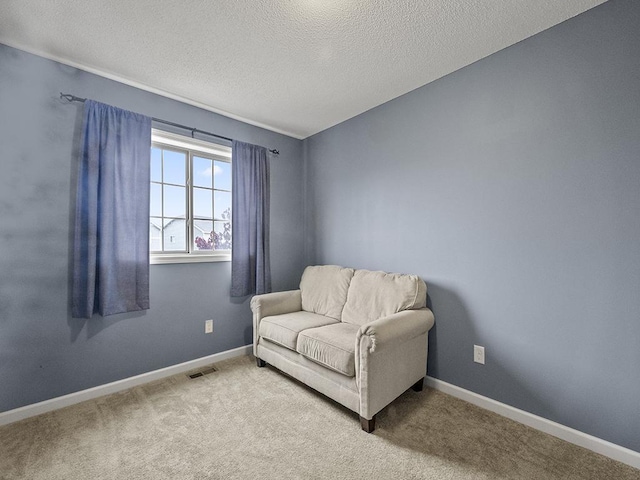 9185 Golden Pond Ln N, Monticello, MN 55362 - sitting room featuring a textured ceiling, baseboards, and carpet