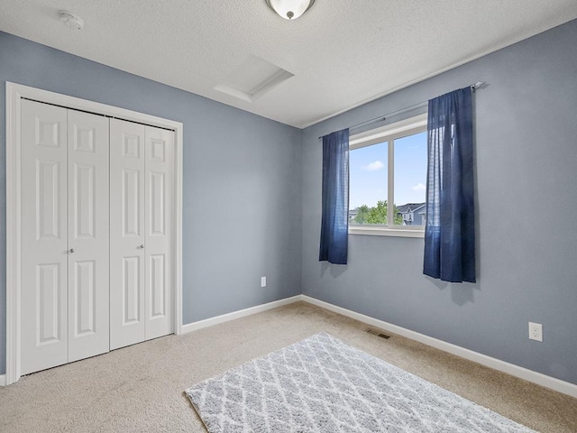 9185 Golden Pond Ln N, Monticello, MN 55362 - bedroom with attic access, carpet flooring, a closet, baseboards, and a textured ceiling