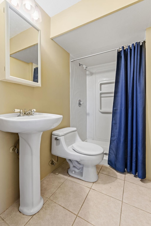 full bathroom with tile patterned flooring, curtained shower, and toilet