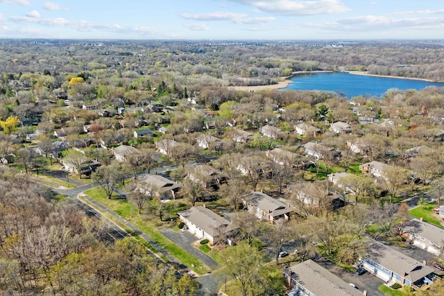 birds eye view of property with a wooded view and a water view