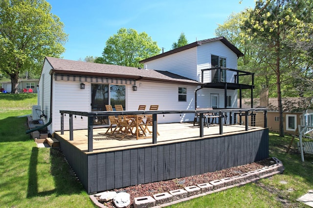 49581 Trowbridge Cir, Candor Twp, MN 56587 - rear view of house featuring a yard, a wooden deck, a shingled roof, and a balcony