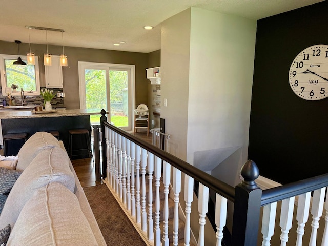 corridor featuring dark carpet, an upstairs landing, and recessed lighting