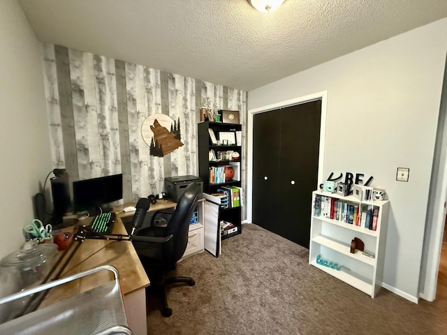 carpeted home office featuring a textured ceiling