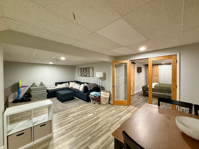 living area with a paneled ceiling, baseboards, recessed lighting, and wood finished floors