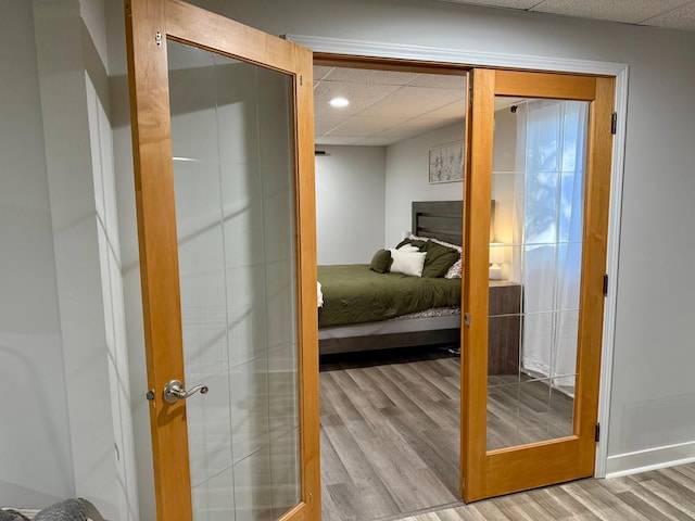 interior space featuring a paneled ceiling, recessed lighting, baseboards, and wood finished floors