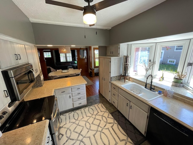 kitchen featuring a sink, stainless steel appliances, a textured ceiling, light countertops, and a ceiling fan