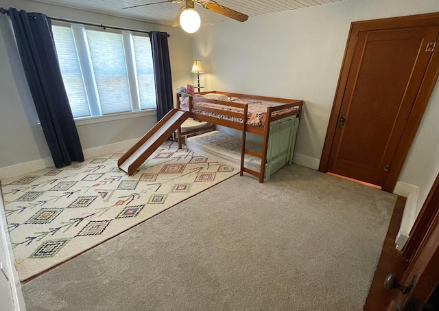 bedroom featuring light colored carpet, baseboards, and ceiling fan
