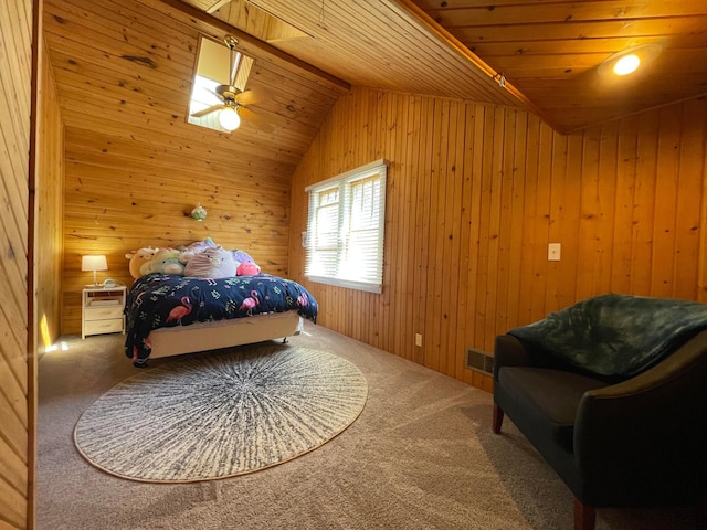 carpeted bedroom with wooden walls, visible vents, ceiling fan, wooden ceiling, and vaulted ceiling