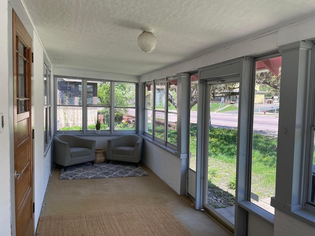 sunroom with a textured ceiling and carpet