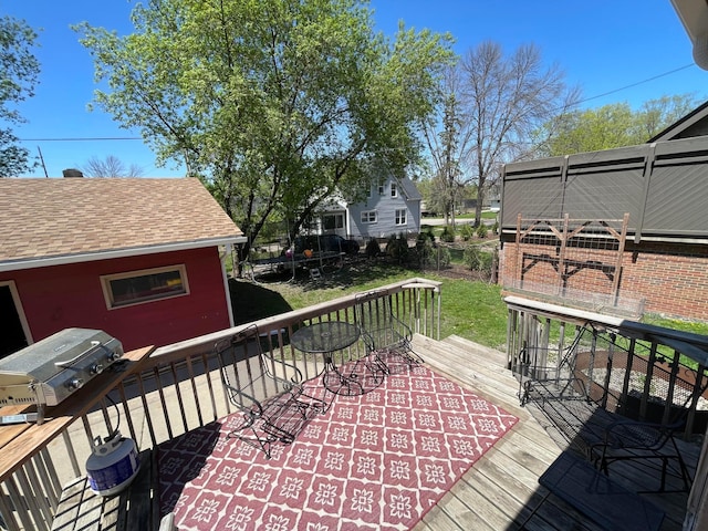 wooden terrace featuring a trampoline and fence