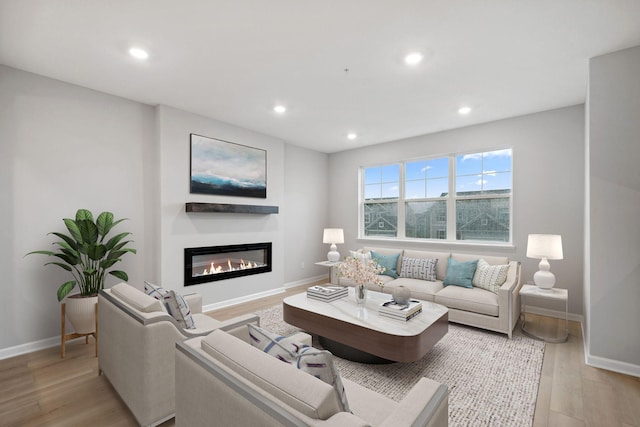 6754 Wildflower Way, Minnetrista, MN 55331 - living area featuring baseboards, recessed lighting, light wood-style floors, and a glass covered fireplace