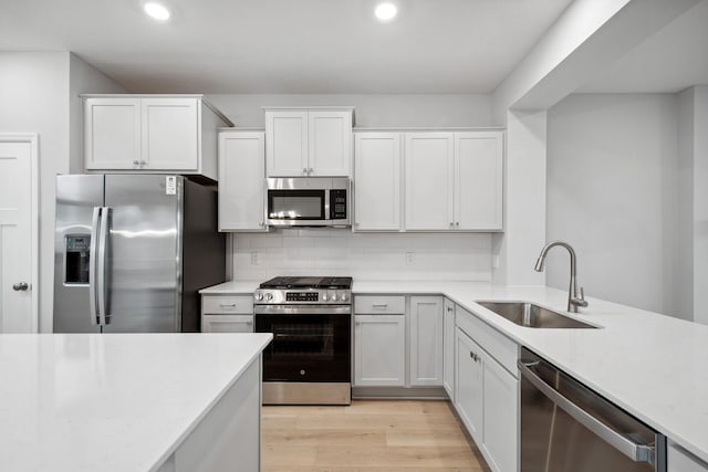 6754 Wildflower Way, Minnetrista, MN 55331 - kitchen with stainless steel appliances, a sink, light countertops, light wood-type flooring, and recessed lighting