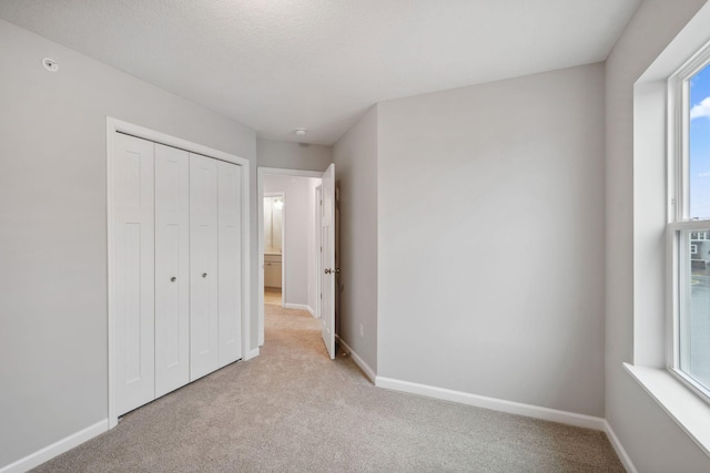 6754 Wildflower Way, Minnetrista, MN 55331 - unfurnished bedroom with light colored carpet, baseboards, and a closet
