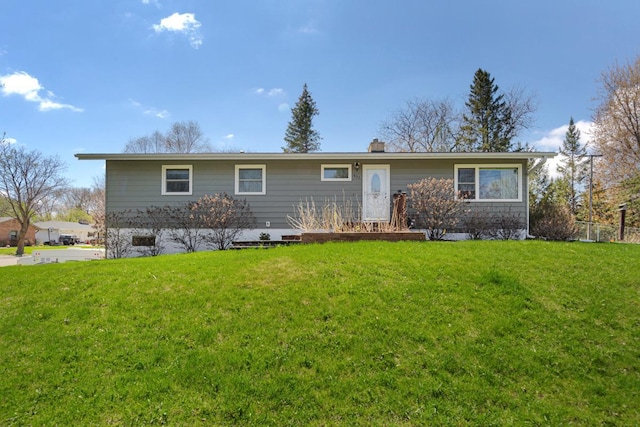 view of front of home featuring a front lawn and a chimney