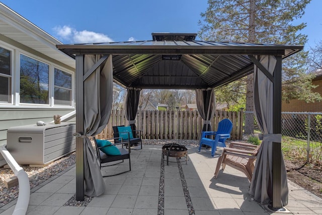 view of patio / terrace with a gazebo, fence, and a fire pit