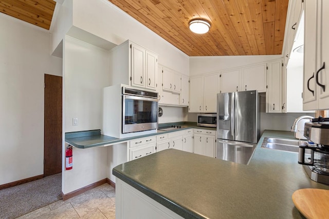 kitchen with wood ceiling, a sink, white cabinetry, dark countertops, and stainless steel appliances