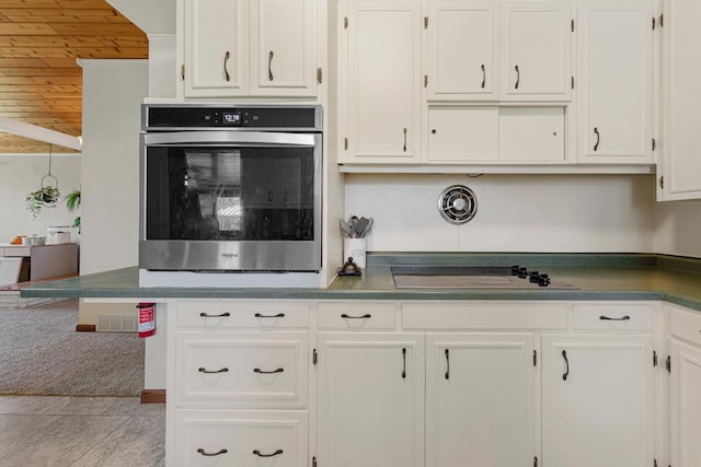 kitchen featuring white cabinetry, electric stovetop, stainless steel oven, and dark countertops