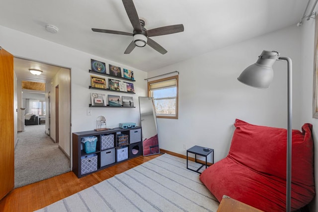 sitting room featuring ceiling fan, baseboards, and wood finished floors