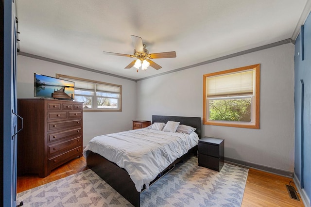 bedroom with light wood-type flooring and ornamental molding