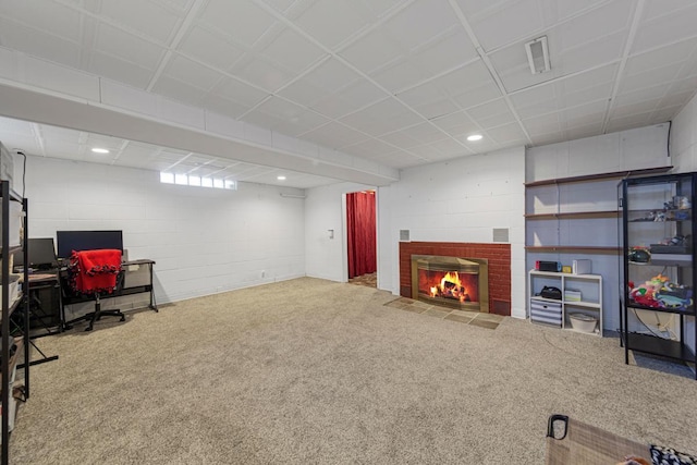 interior space featuring carpet, visible vents, concrete block wall, and a brick fireplace
