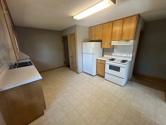kitchen featuring white appliances, a sink, light floors, under cabinet range hood, and baseboards