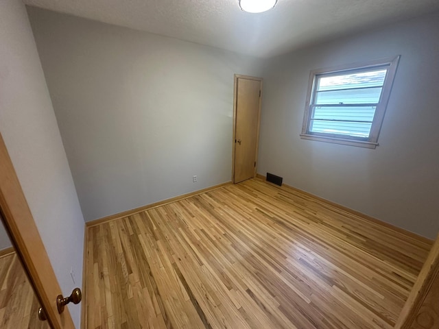 empty room featuring light wood-style flooring and baseboards