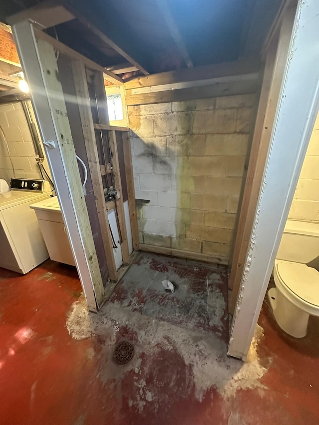 full bathroom featuring washer / clothes dryer, unfinished concrete flooring, and a stall shower