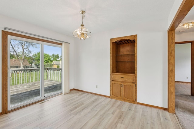 3697 75th St E, Inver Grove Heights, MN 55076 - unfurnished dining area featuring a chandelier, light wood finished floors, and baseboards
