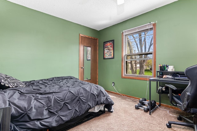 bedroom featuring an office area, carpet floors, a textured ceiling, a ceiling fan, and baseboards