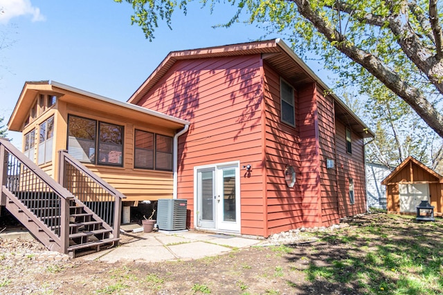 back of house featuring central AC unit and stairway